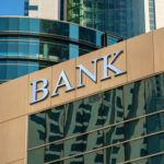 Ein Bildausschnitt eines Gebäudes mit Glasfassade und der Aufschrift "Bank"