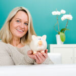 Beitragsbild mit einer Dame, welche glücklich ein Sparschwein in den Händen hält