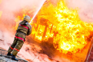 Ein Feuerwehrmann kämpft gegen die Flammen eines brennenden Hauses