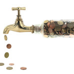 Geldmünzen fallen aus einem Wasserhahn