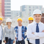 Fünf Personen mit Schutzhelmen auf Baustelle