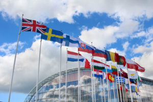 Internationale Flaggen im Wind vor strahlend blauem Himmel