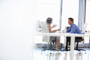 Zwei Personen unterhalten sich in einem Büro