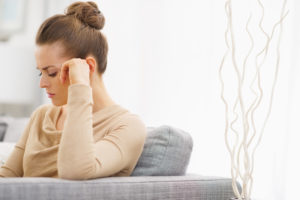 Eine ärgerliche Frau sitzt auf einer Couch